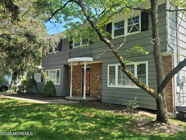 view of front of home featuring brick siding and a front lawn