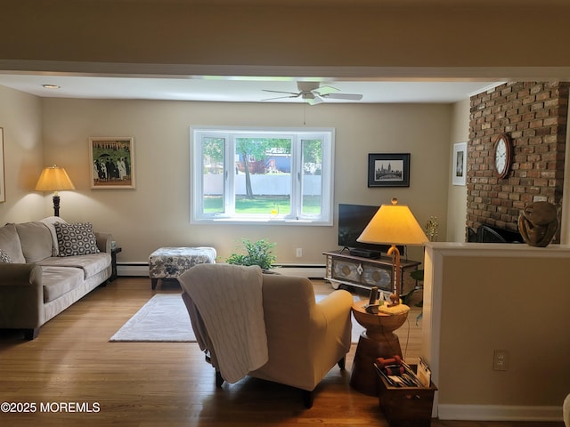 living area featuring baseboard heating, a ceiling fan, a baseboard heating unit, and wood finished floors