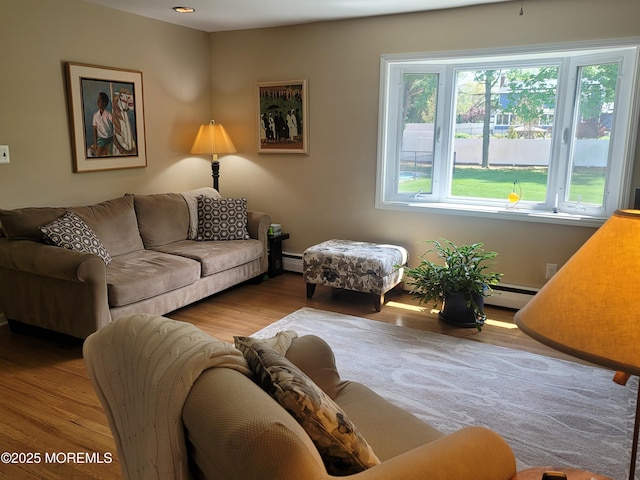 living area featuring a baseboard heating unit and wood finished floors