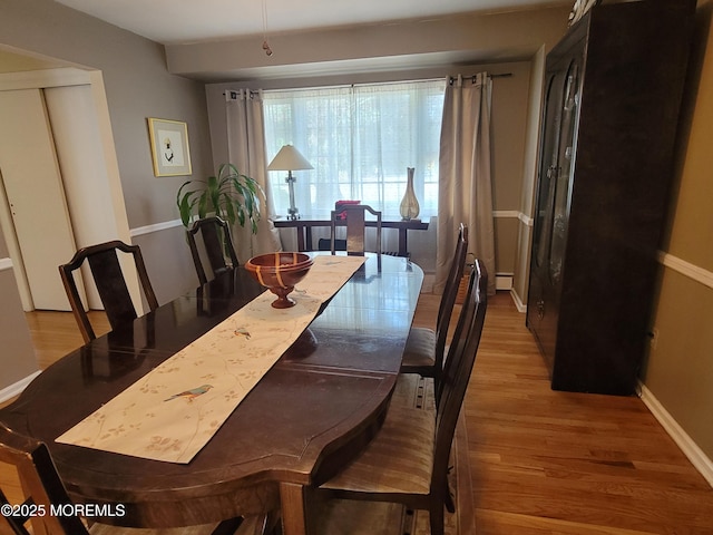 dining area with baseboards and wood finished floors