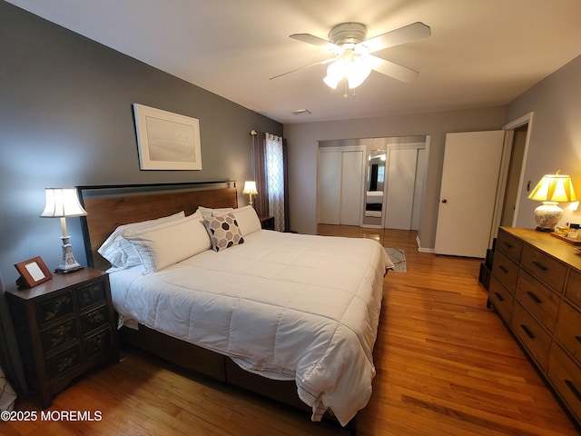 bedroom with visible vents, ceiling fan, wood finished floors, and a closet