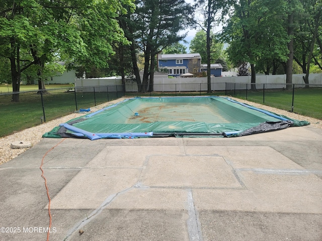 view of swimming pool featuring a yard, fence, a fenced in pool, and a patio area