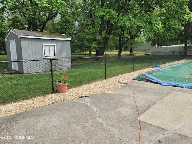 view of patio / terrace featuring a storage unit, fence, and an outbuilding