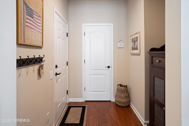 doorway to outside with baseboards and dark wood-type flooring