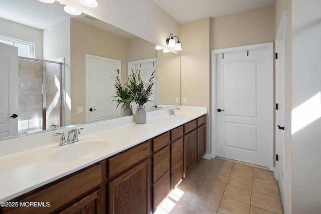 bathroom with a sink, tile patterned flooring, walk in shower, visible vents, and double vanity
