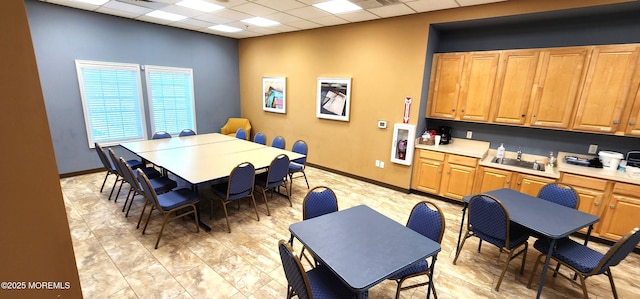 dining space featuring baseboards and a paneled ceiling