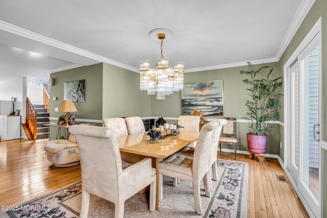 265 Marigold Ct, Toms River, NJ 08757 - dining space with crown molding, stairway, an inviting chandelier, baseboards, and light wood-style flooring
