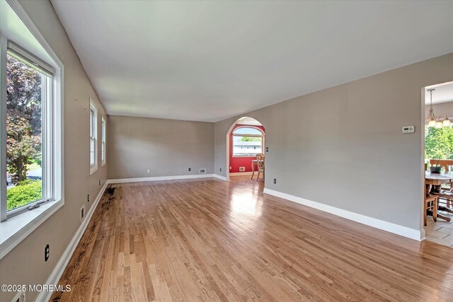 7 Mill Rd, Jamesburg, NJ 08831 - spare room featuring light wood-style floors, a healthy amount of sunlight, baseboards, and arched walkways