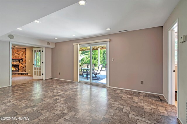 7 Mill Rd, Jamesburg, NJ 08831 - empty room with a healthy amount of sunlight, stone tile flooring, and a stone fireplace