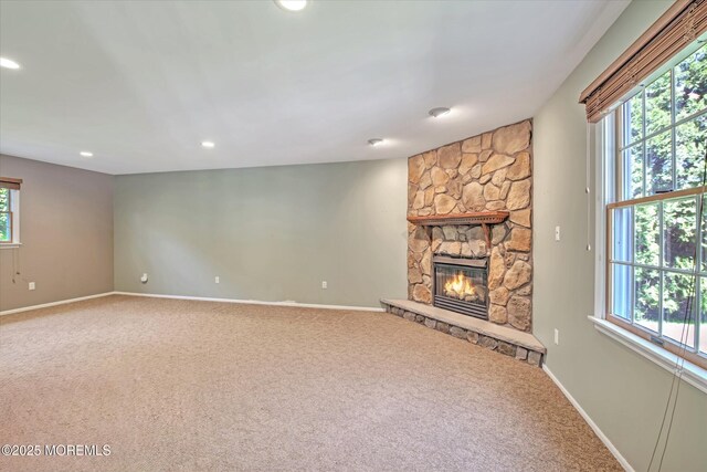 7 Mill Rd, Jamesburg, NJ 08831 - unfurnished living room with a wealth of natural light, baseboards, a stone fireplace, and carpet floors