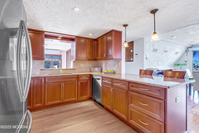 148 Royal Dr, Brick, NJ 08723 - kitchen featuring a textured ceiling, a peninsula, brown cabinets, light wood-type flooring, and stainless steel appliances