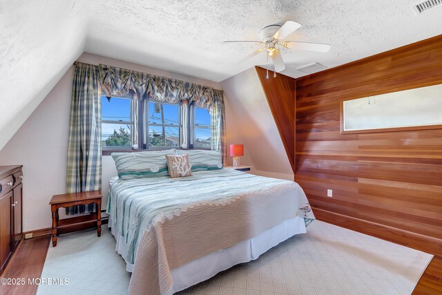 148 Royal Dr, Brick, NJ 08723 - bedroom featuring a ceiling fan, wooden walls, a textured ceiling, lofted ceiling, and visible vents