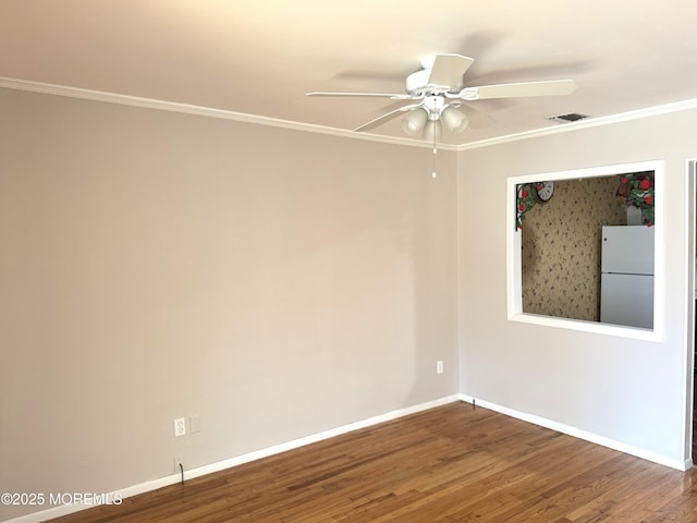 empty room featuring baseboards, ornamental molding, wood finished floors, and ceiling fan