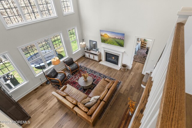 61 Windermere Rd, Lincroft, NJ 07738 - living area featuring a fireplace with flush hearth, baseboards, a high ceiling, and wood finished floors