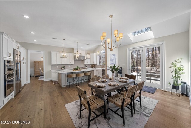 61 Windermere Rd, Lincroft, NJ 07738 - dining area featuring a skylight, baseboards, recessed lighting, light wood-type flooring, and a notable chandelier