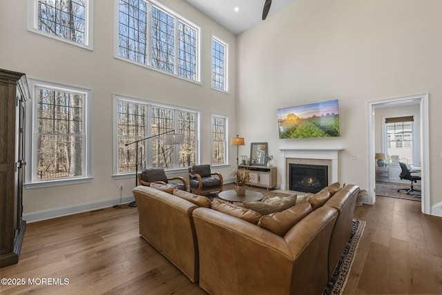 61 Windermere Rd, Lincroft, NJ 07738 - living area featuring a fireplace with flush hearth, baseboards, a high ceiling, and wood finished floors