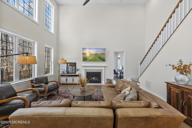 61 Windermere Rd, Lincroft, NJ 07738 - living area featuring visible vents, baseboards, stairs, wood finished floors, and a lit fireplace