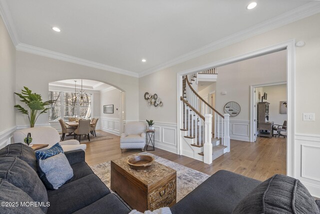 61 Windermere Rd, Lincroft, NJ 07738 - living room featuring stairs, ornamental molding, arched walkways, a notable chandelier, and wood finished floors