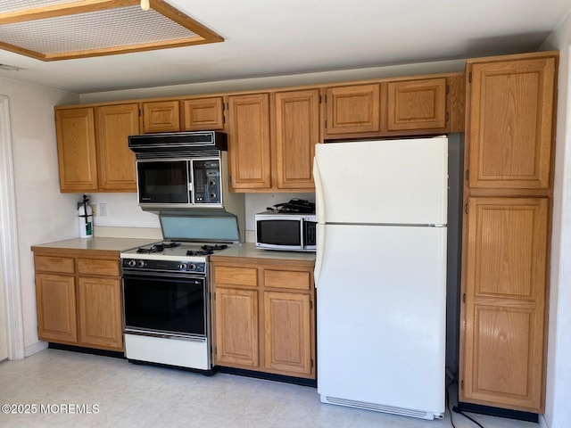 1042A Canterbury Dr, Manchester, NJ 08759 - kitchen featuring light countertops, stainless steel microwave, gas stove, freestanding refrigerator, and black microwave
