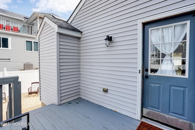 doorway to property featuring cooling unit and a wooden deck