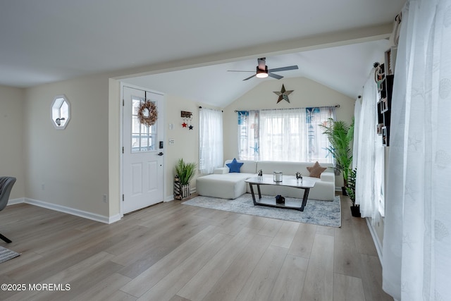 living area featuring plenty of natural light, vaulted ceiling, light wood-type flooring, and a ceiling fan