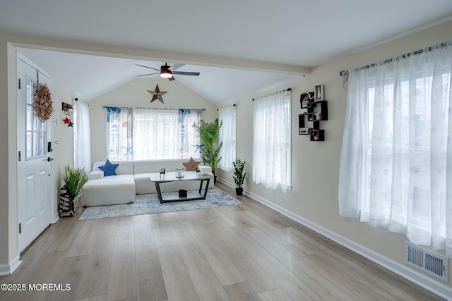 unfurnished living room featuring light wood-type flooring, baseboards, visible vents, a ceiling fan, and vaulted ceiling with beams