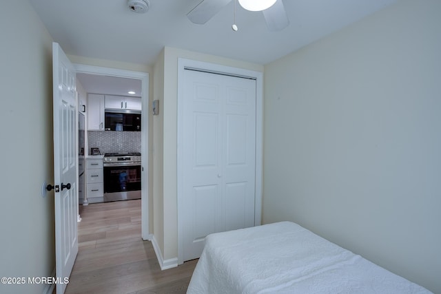 bedroom featuring a ceiling fan, light wood-style flooring, and a closet