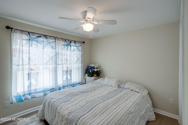 bedroom with baseboards, wood finished floors, and ceiling fan