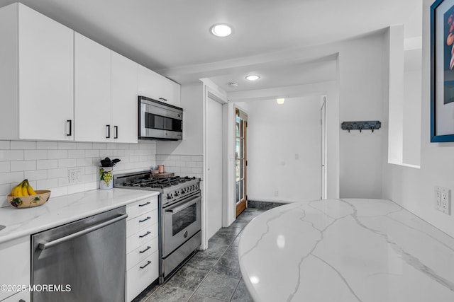 kitchen with light stone counters, white cabinetry, tasteful backsplash, appliances with stainless steel finishes, and recessed lighting