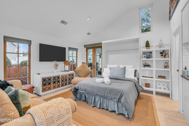 bedroom featuring light wood finished floors, visible vents, high vaulted ceiling, and french doors