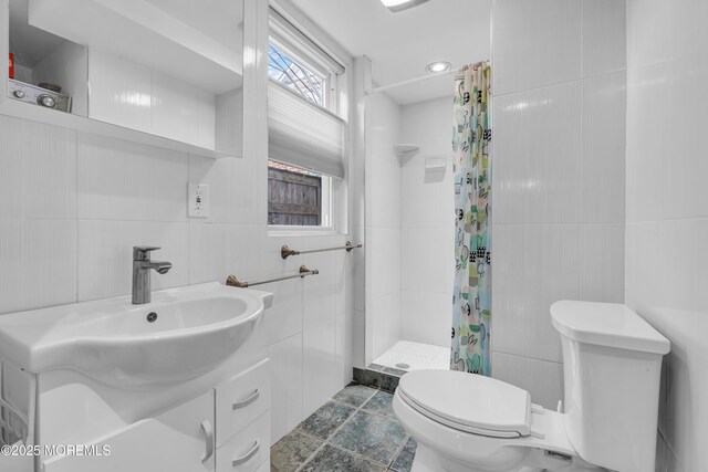full bathroom featuring tile walls, vanity, toilet, and a shower stall