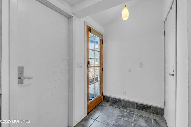 doorway to outside with stone finish floor and baseboards