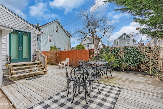 deck with a fenced backyard, outdoor dining area, and entry steps