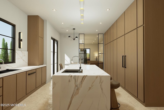 721 Corlies Ave, Allenhurst, NJ 07711 - kitchen with light marble finish flooring, an island with sink, modern cabinets, backsplash, and recessed lighting