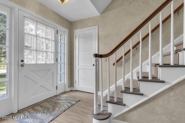 foyer featuring wood finished floors and stairway