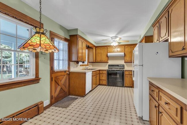 kitchen featuring black gas stove, brown cabinets, under cabinet range hood, and a baseboard radiator