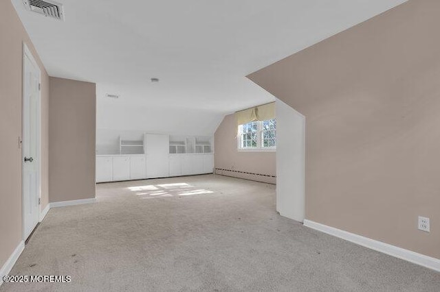 additional living space featuring vaulted ceiling, a baseboard heating unit, carpet flooring, baseboards, and visible vents