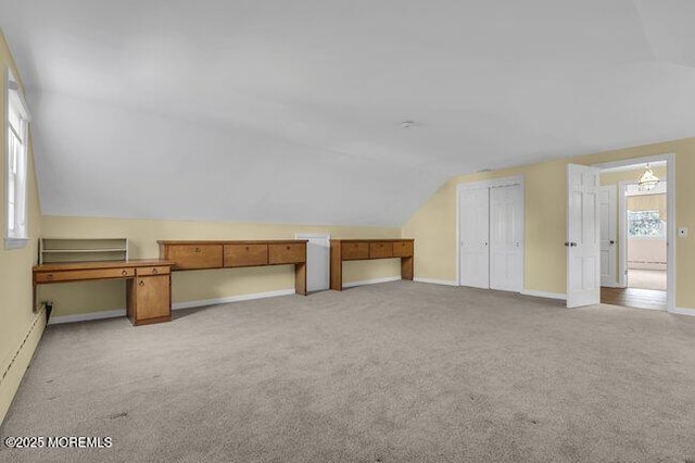additional living space featuring baseboards, a baseboard radiator, vaulted ceiling, and light carpet