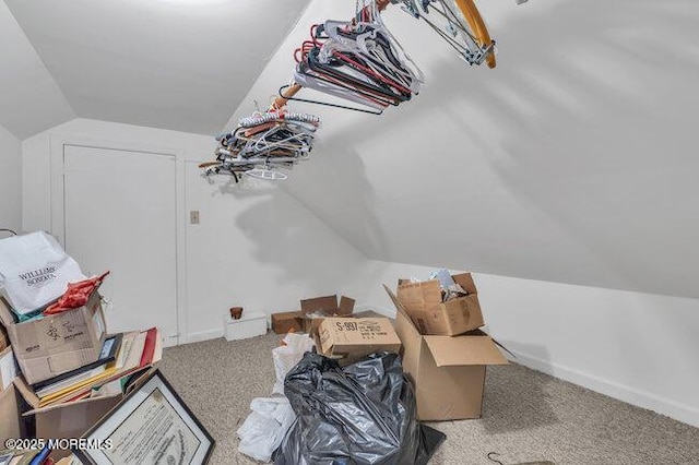 interior space featuring baseboards, vaulted ceiling, and carpet flooring