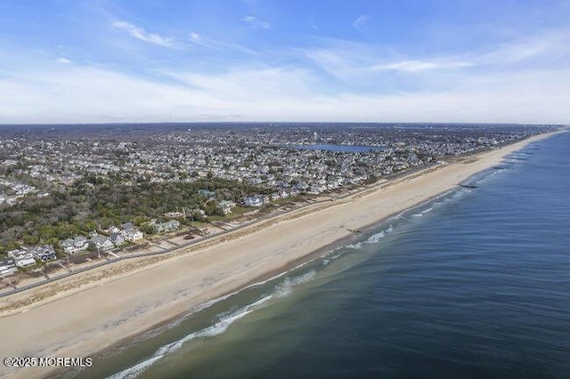 birds eye view of property with a water view and a beach view