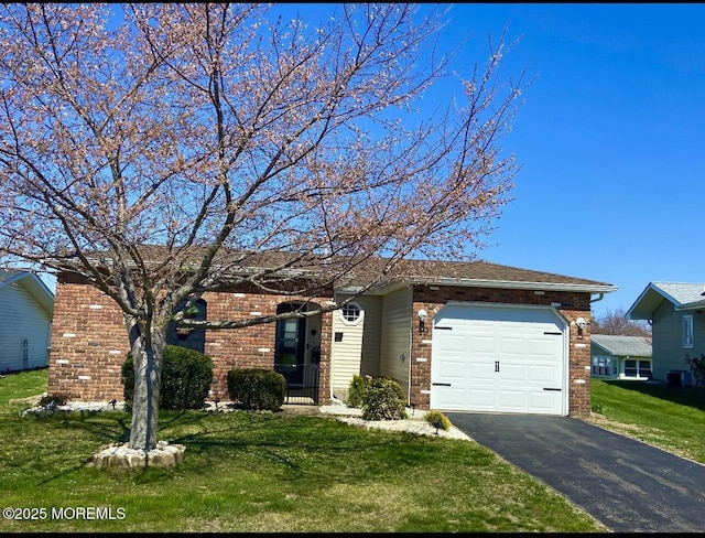 ranch-style house featuring aphalt driveway, a front lawn, an attached garage, and brick siding