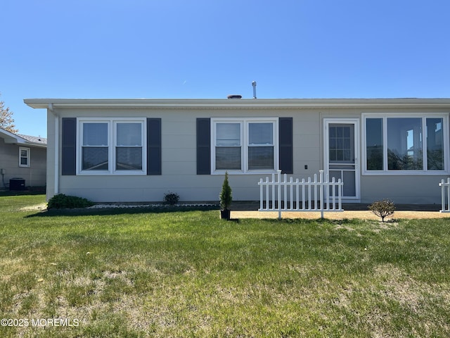 view of front of home featuring cooling unit and a front lawn