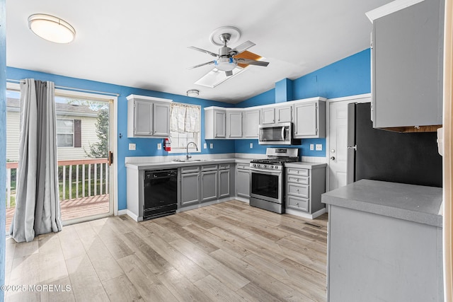 kitchen with stainless steel appliances, gray cabinets, ceiling fan, light countertops, and lofted ceiling