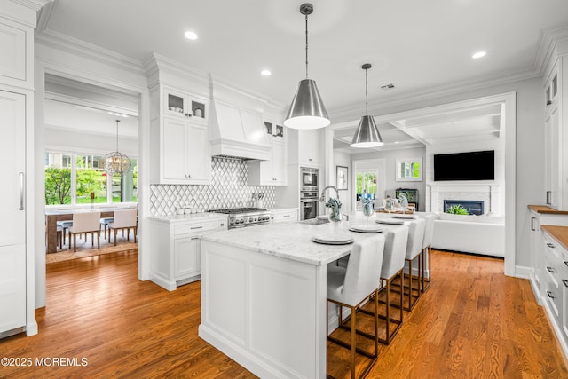 11 Beacon Hill Rd, Atlantic Highlands, NJ 07716 - kitchen with white cabinets, a fireplace, wood finished floors, glass insert cabinets, and recessed lighting