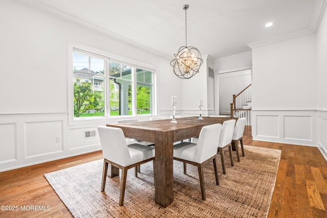 11 Beacon Hill Rd, Atlantic Highlands, NJ 07716 - dining area with a decorative wall, a chandelier, crown molding, stairway, and wood finished floors