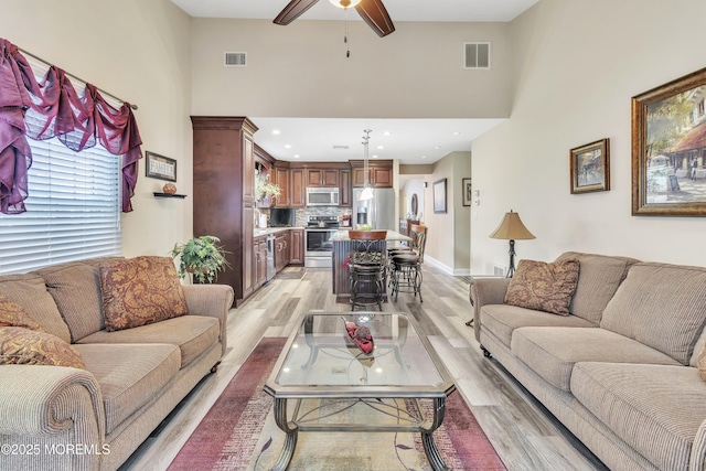 1792 Buttonwood Ave, Toms River, NJ 08755 - living room featuring light wood-type flooring, a towering ceiling, a ceiling fan, and visible vents