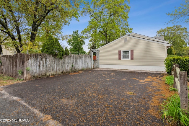 view of property exterior with fence and driveway