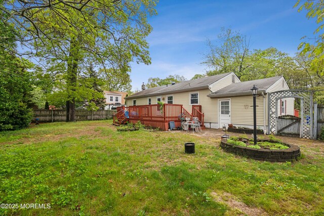 rear view of property featuring a wooden deck and a gate