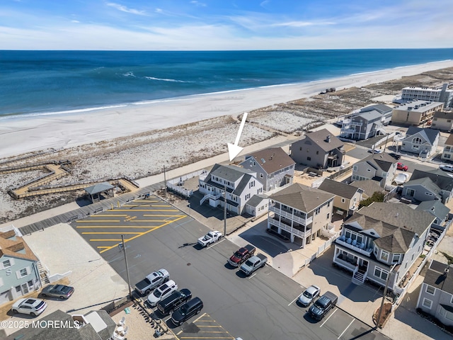 birds eye view of property featuring a beach view and a water view