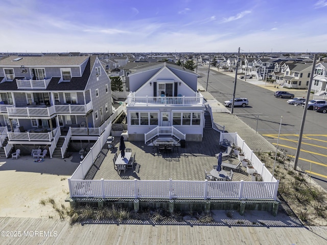 rear view of property with stairway, a fenced backyard, a residential view, and a balcony